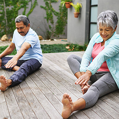 two elderly people stretching