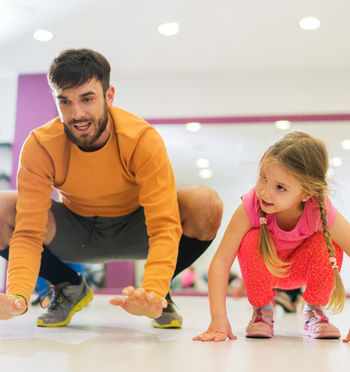 a group fitness trainer teaching a young girl about fitness