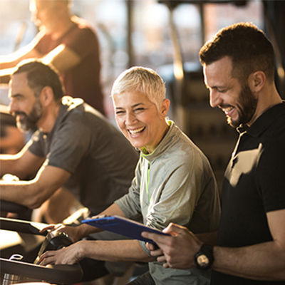 a group fitness trainer talking with a woman in a group class