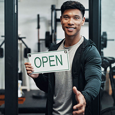 a personal trainer holding a open sign