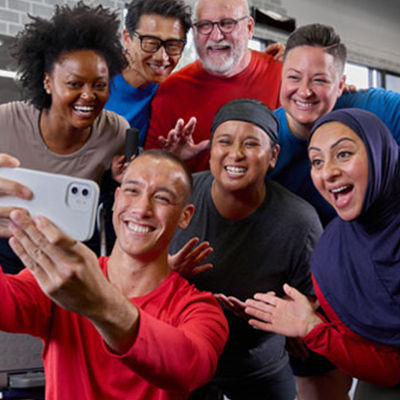 a group taking a picture with their group fitness instructor